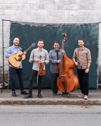 Les membres du groupe posant avec leurs instruments de musique