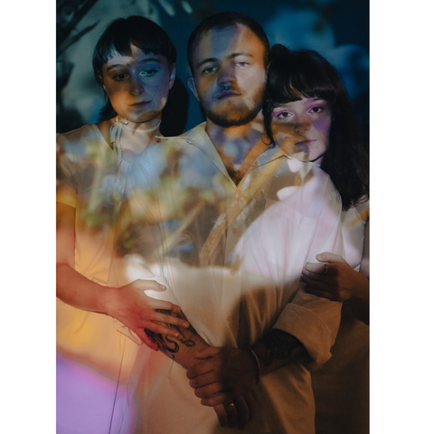 Une image colorée des 3 artistes dont 2 femmes encadrant 1 homme de gauche à droite.